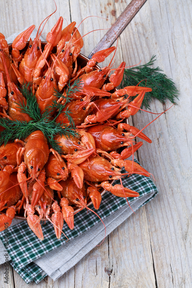 Copper frying pan with red boiled crawfish on a wooden table Copper frying pan with red boiled crawfish on a wooden table