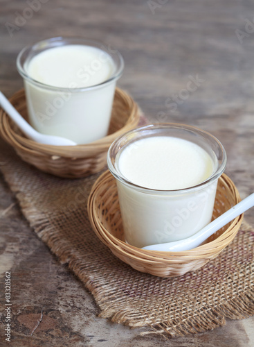 Two small jars homemade yogurt in a wicker baskets