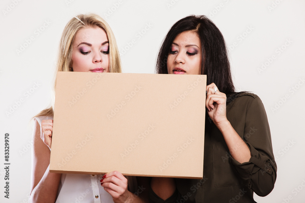 two women holding blank board two women holding blank board