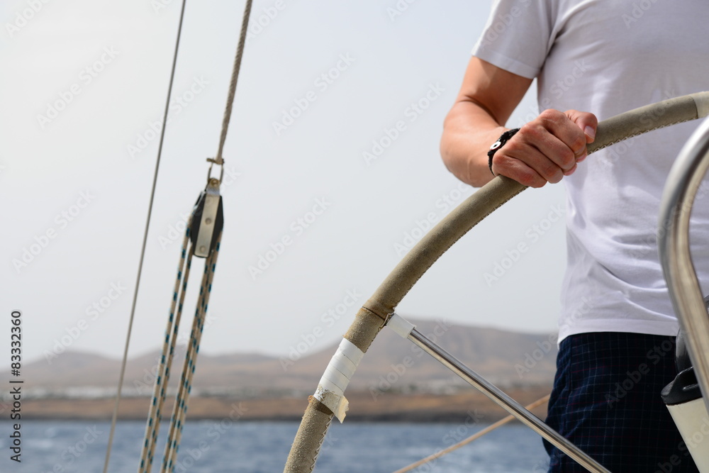 Obraz premium Manos Sobre el Timón de un Velero