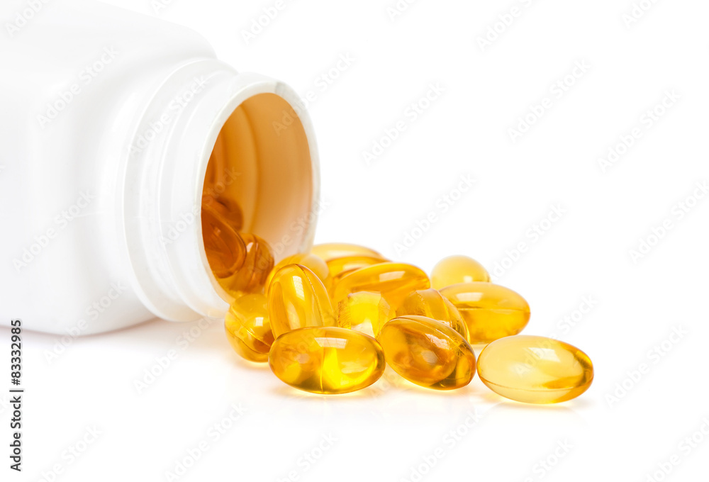 Fish oil capsules spill out of a white bottle