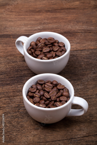cup of coffee beans on the brown wooden background