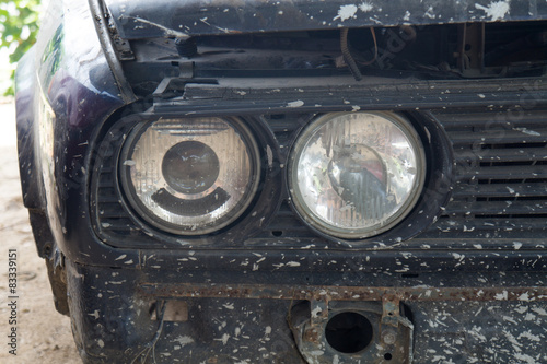 A closeup of the headlights and front bumper on a vintage