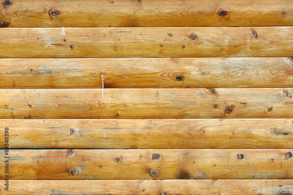 Naklejka premium Large wooden wall of yellow parallel logs