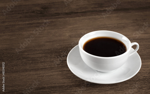 Cup of hot coffee on a wooden table.