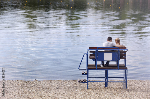 Arms around each other loving couple sitting at lake