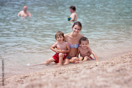 Young mother with her children on the beach
