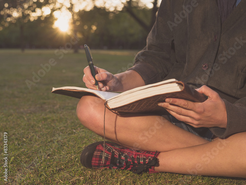 Photography Woman writing in notebook at sunset