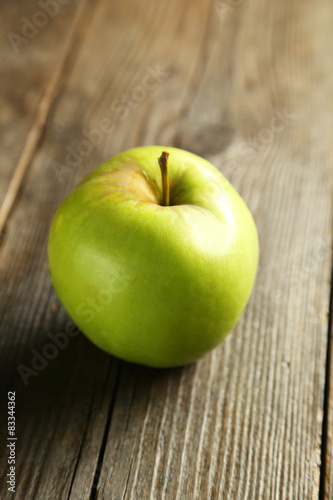 Green apple on brown wooden background