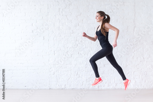 Side view of active sporty young running woman runner athlete
