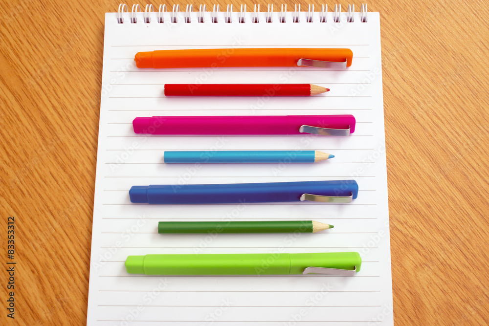 Fototapeta premium colored pens on a notepad on the table
