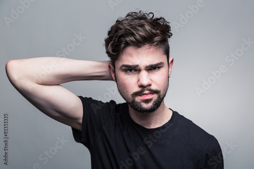 Young man in black T-shirt doubting
