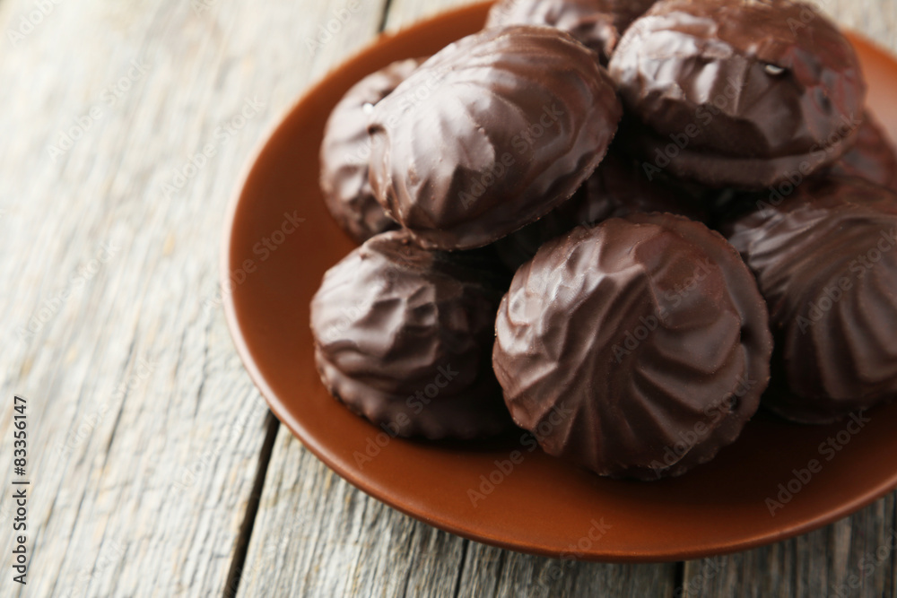 Zephyr in chocolate on plate on grey wooden background Zephyr in chocolate on plate on grey wooden background