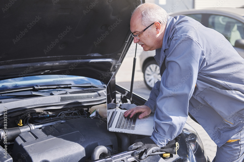 Professional mechanic using contemporary technology at work Professional mechanic using contemporary technology at work