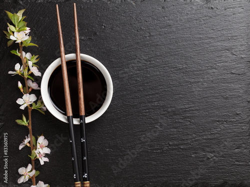 Japanese sushi chopsticks, soy sauce bowl and sakura blossom