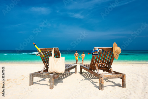 Couple in yellow running on a beach at Maldives