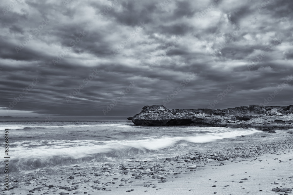 Black and white landscape of ocean rocks and clouds artistic con