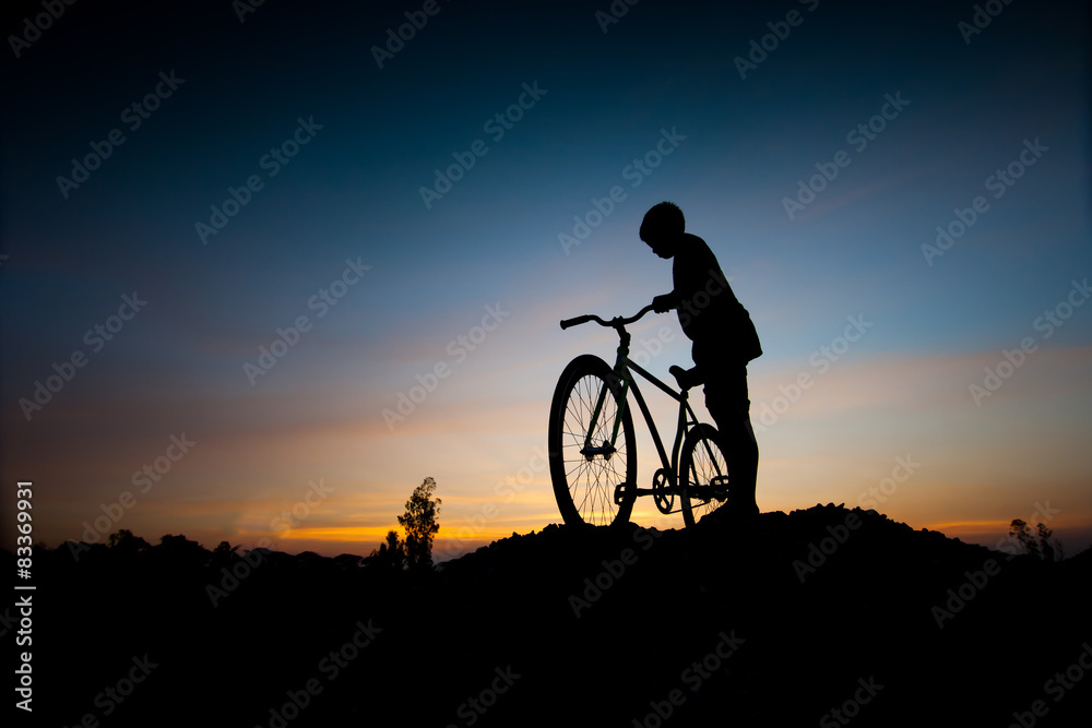Obraz premium silhouette of children and bicycle at sunset