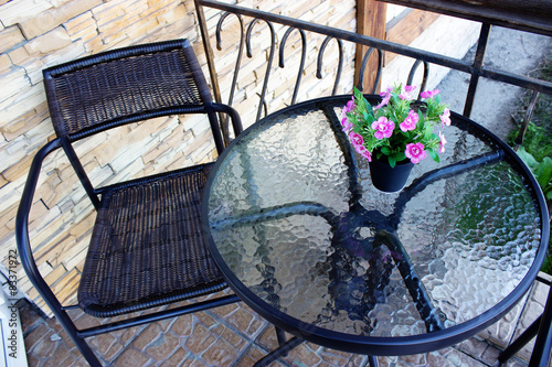 wicker chair glass table with a flower place to relax