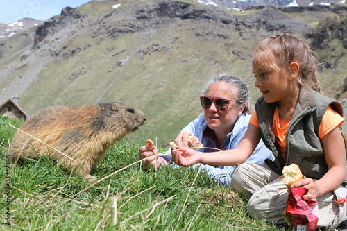 mère et fille donnant à manger à une marmotte