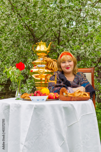 Beautiful Russian girl with a curvaceous, rosy and happy sitting photo