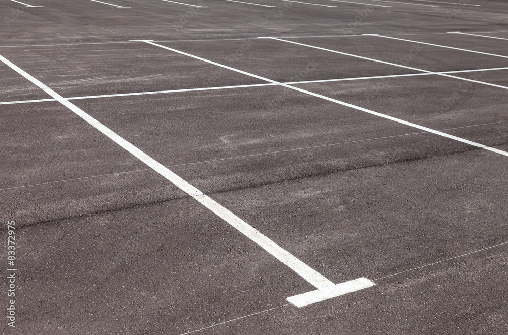 White traffic markings on a gray asphalt parking lot