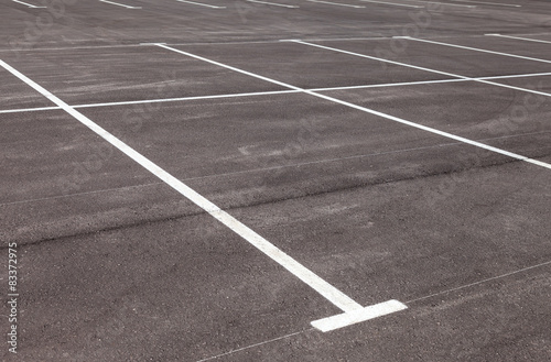 White traffic markings on a gray asphalt parking lot © Alexandr Blinov