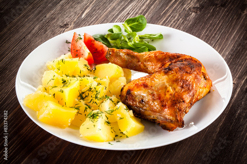 Barbecued chicken leg with boiled potatoes and vegetables