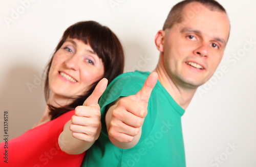 Smiling woman and man showing thumbs up