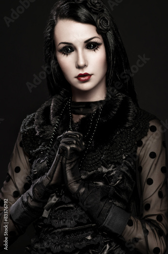 Portrait of girl-alien with black eyes in dark clothes