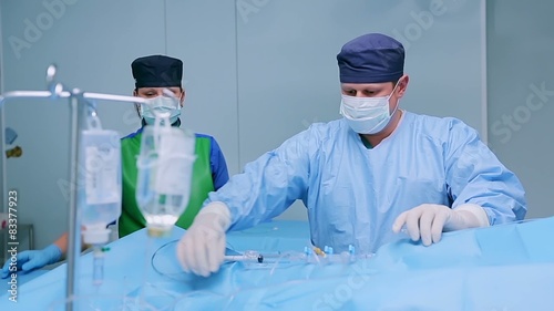 A surgeon inserts a wire tool into catheter  