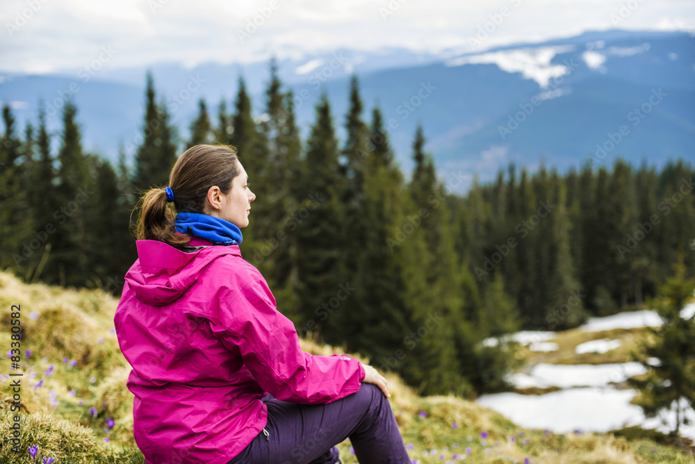 young caucasian girl sitting outdoors in mountains