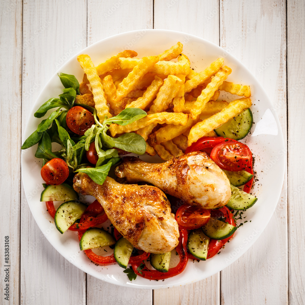 Grilled chicken drumsticks with chips and vegetables Grilled chicken drumsticks with chips and vegetables