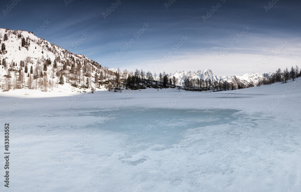 Lago alpino ghiacciato all'alba
