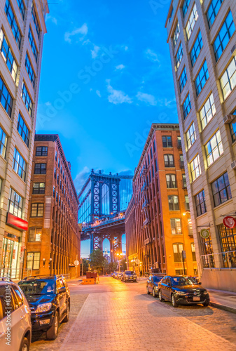 The Manhattan Bridge framed at night by Brooklyn buildings photo