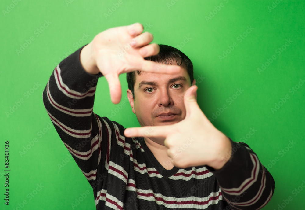 man looking through the hands of the frame on a green background man looking through the hands of the frame on a green background