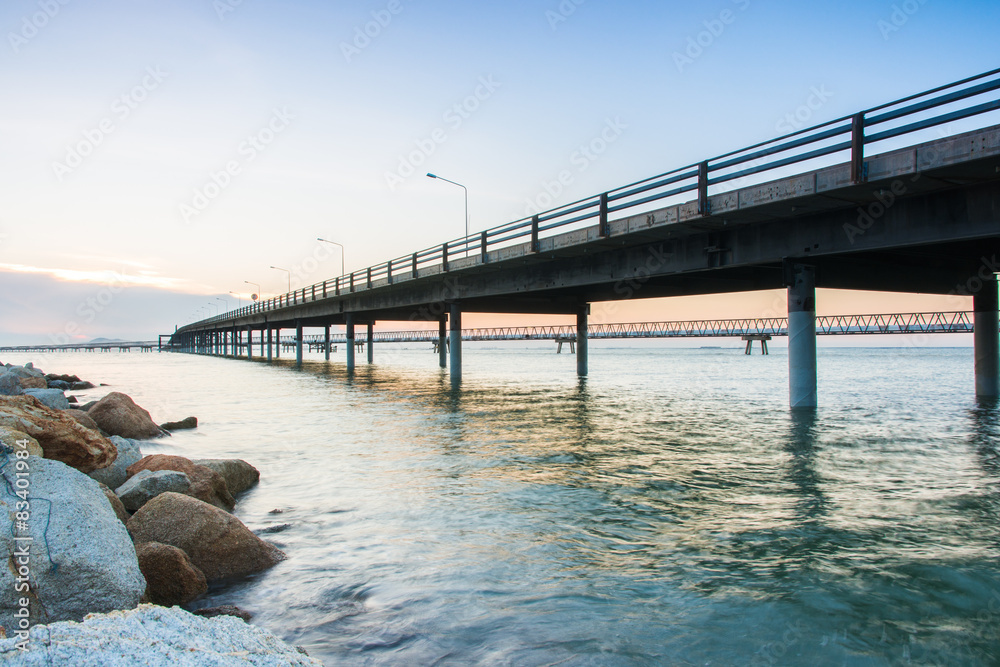 Concrete Bridge over sea water with sunrise