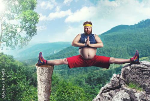 Overweight man doing splits photo