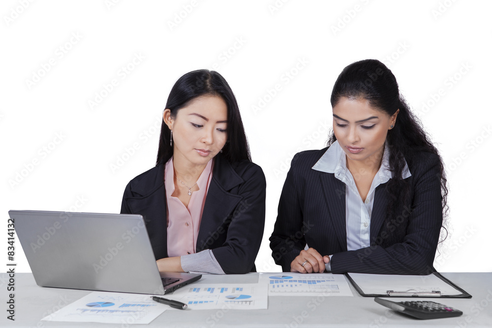 Two women working with documents on desk Two women working with documents on desk