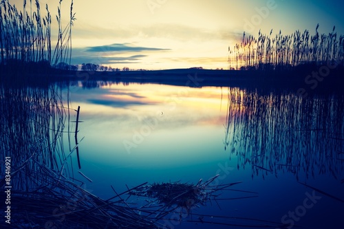 Vintage photo of beautiful sunset over calm lake #83416921