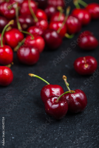 Fresh ripe organic cherries on black border  background