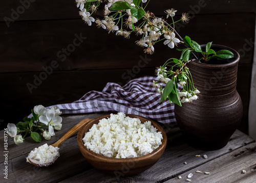 Cottage cheese in a bowl on wooden table