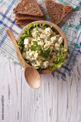 egg salad and bread vertical top view, rustic style
