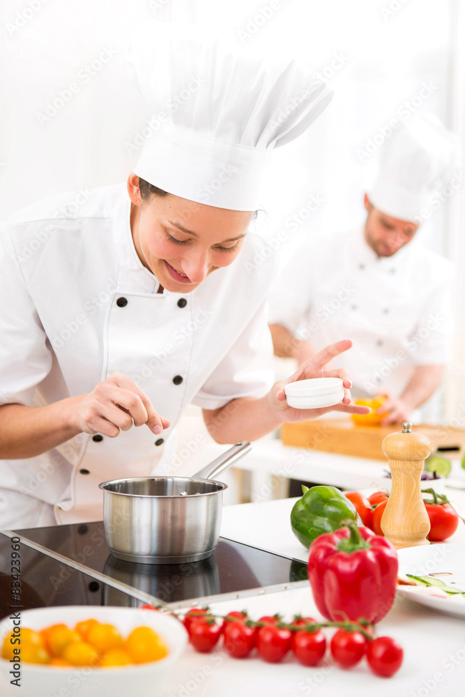 Young attractive professional chef cooking in his kitchen