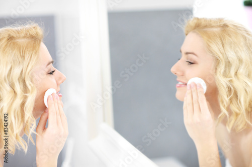 Happy woman cleaning face