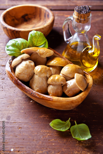  pickled white mushrooms in wooden bowl on vintage wood with bas