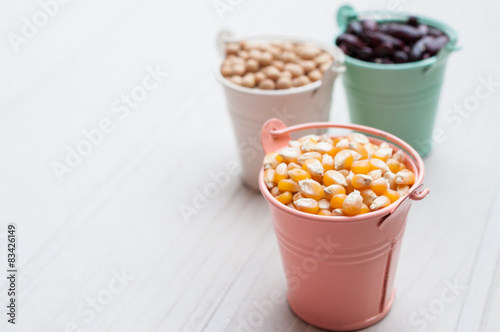 Bulk of corn grain on wooden table, macrobiotic food or healthy