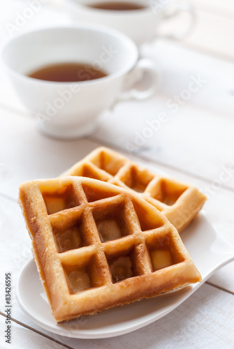waffles and tea on white wooden board