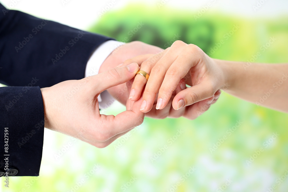 Obraz premium Woman and man holding wedding rings, close-up, on bright background