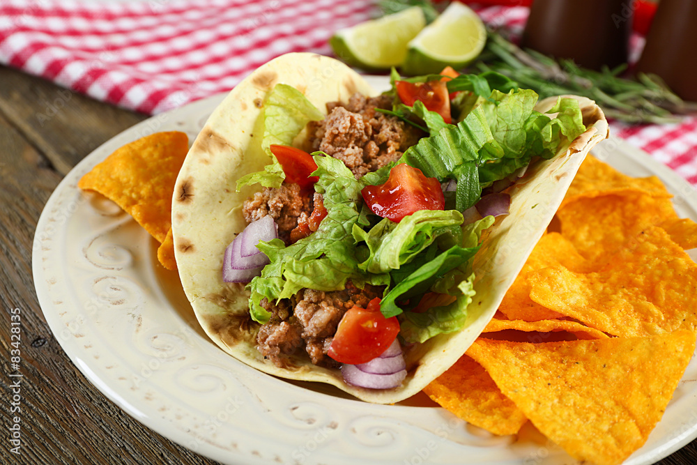 Mexican food Taco in plate on wooden table, closeup Mexican food Taco in plate on wooden table, closeup